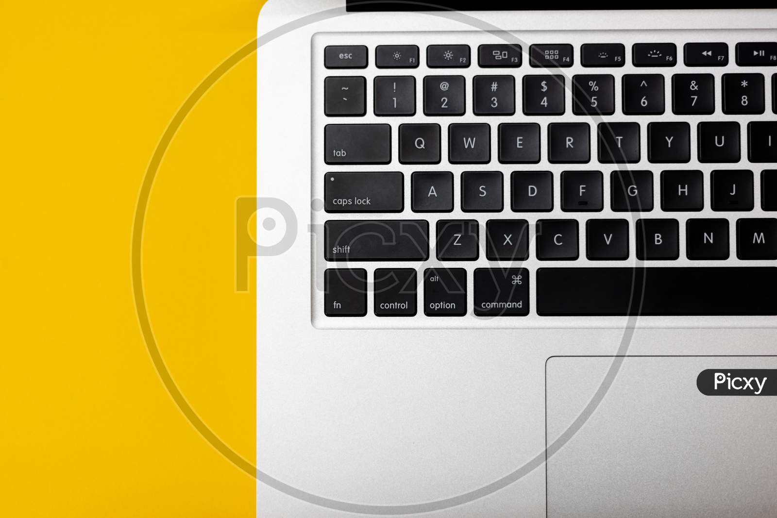 Flat lay, top view of Laptop computer keyboard on a bright yellow background