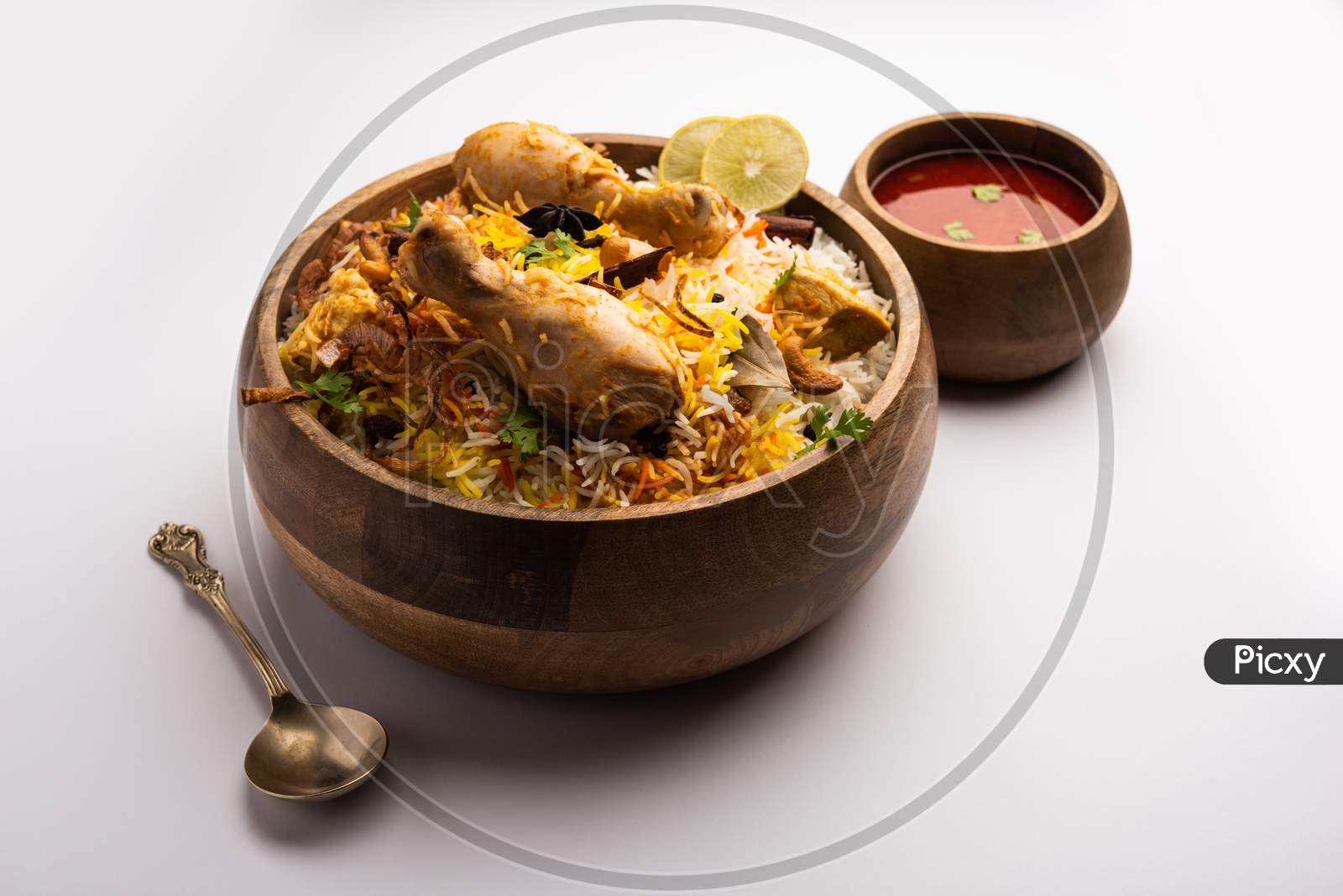 Image of Indian Chicken Biryani Served In A Terracotta Bowl With Yogurt