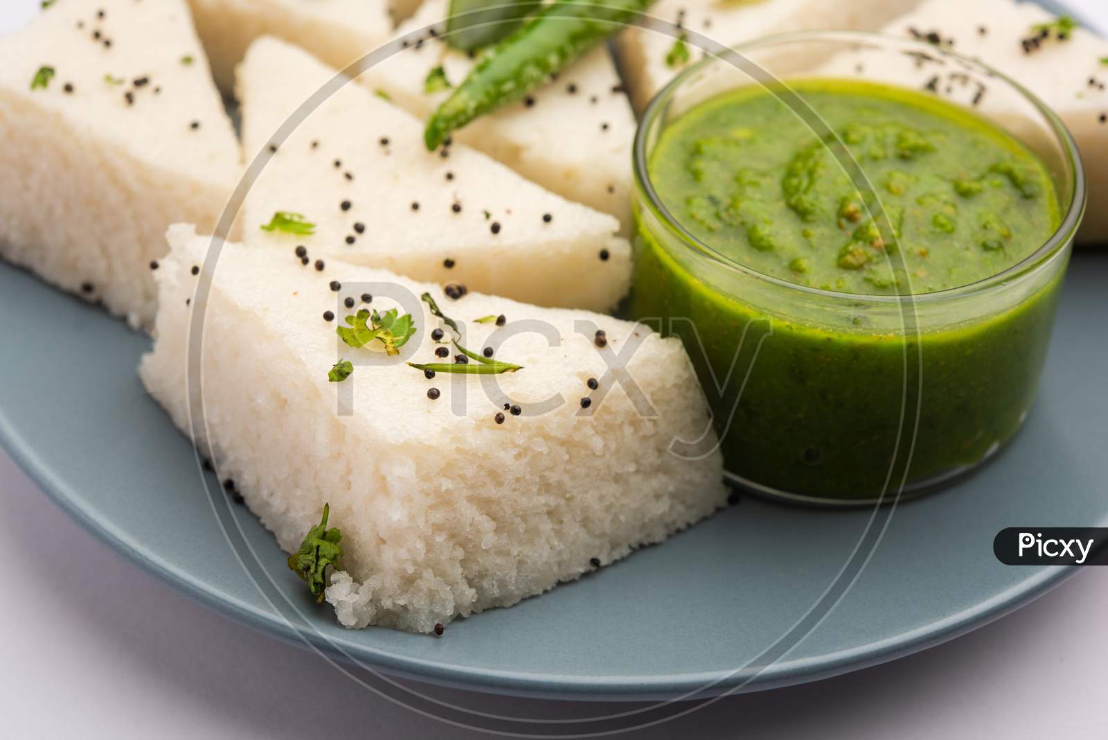 Khaman White Dhokla Made Up Of Rice Or Urad Dal Is A Popular Breakfast Or Snacks Recipe From Gujrat, India, Served With Green Chutney And Hot Tea. Selective Focus