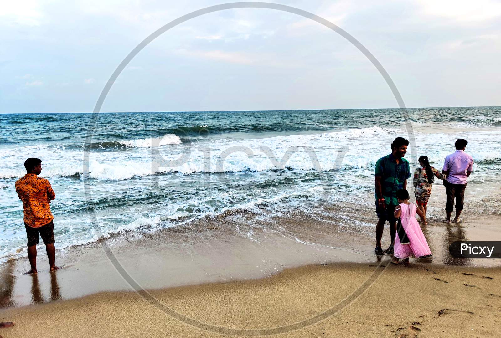 Some People Enjoying The Waves Of The Sea In Chennai