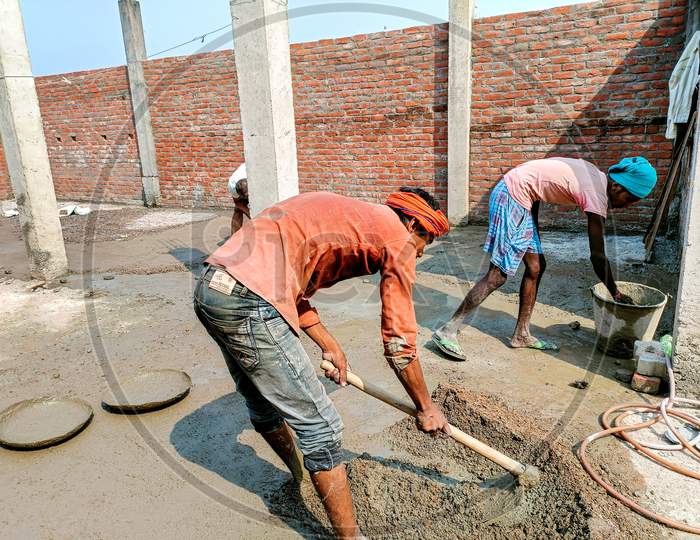 Indian Workers Doing Construction Work Manually On Floor Using A Shovel