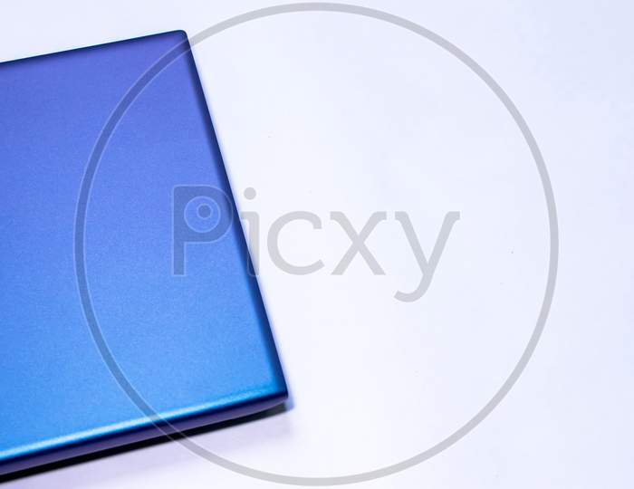 Folded Blue Laptop'S Corner In White Background