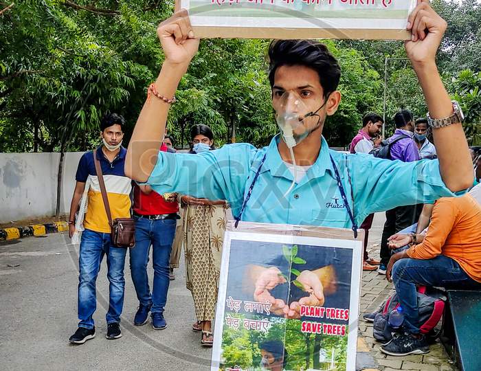 A Young Adult Boy Holds Up A Poster For Saving Trees Campaign