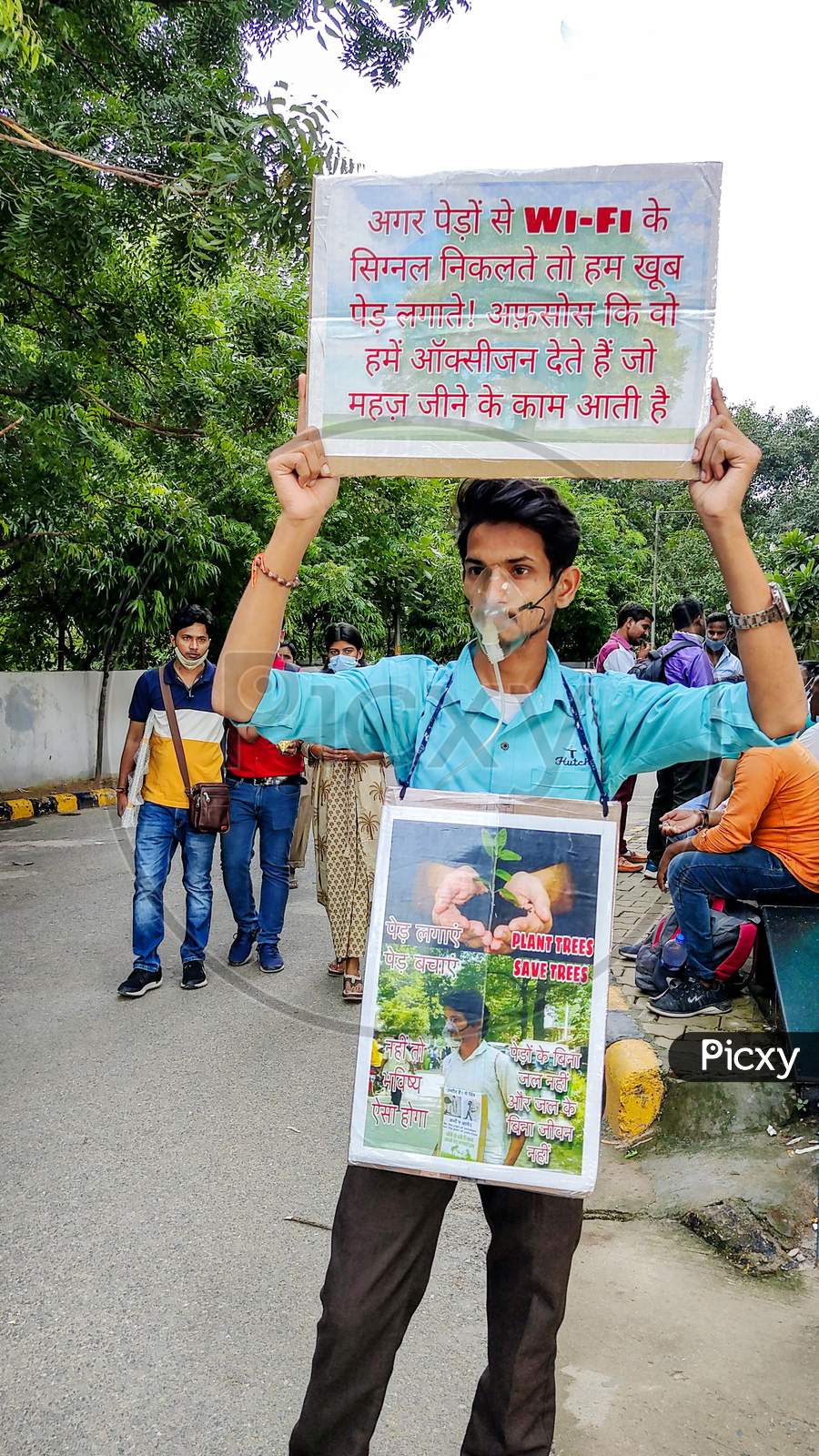 A Young Adult Boy Holds Up A Poster For Saving Trees Campaign
