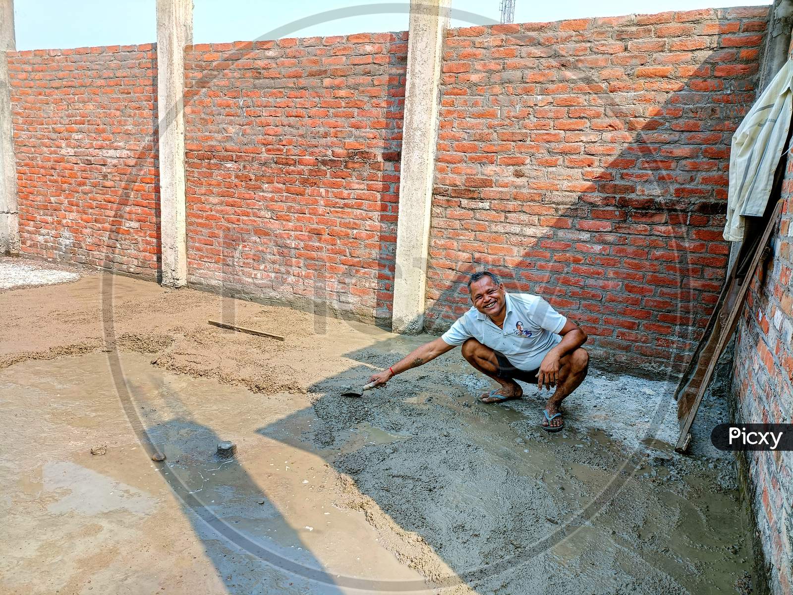 Indian Workers Doing Construction Work Manually On Floor Using A Shovel
