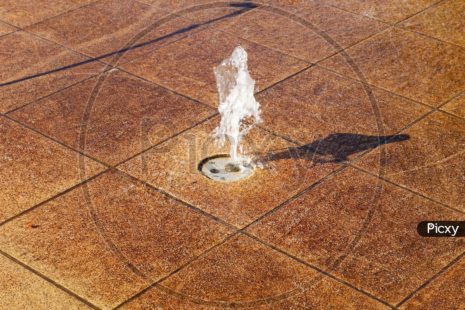 Surface Of Moving Water Reflecting Sunlight In A Fountain Found In Germany.