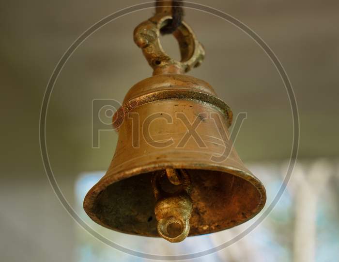 Old bronze bell in indian temple with blur background. Hindu temple brass  bell hanging in gold color Stock Photo