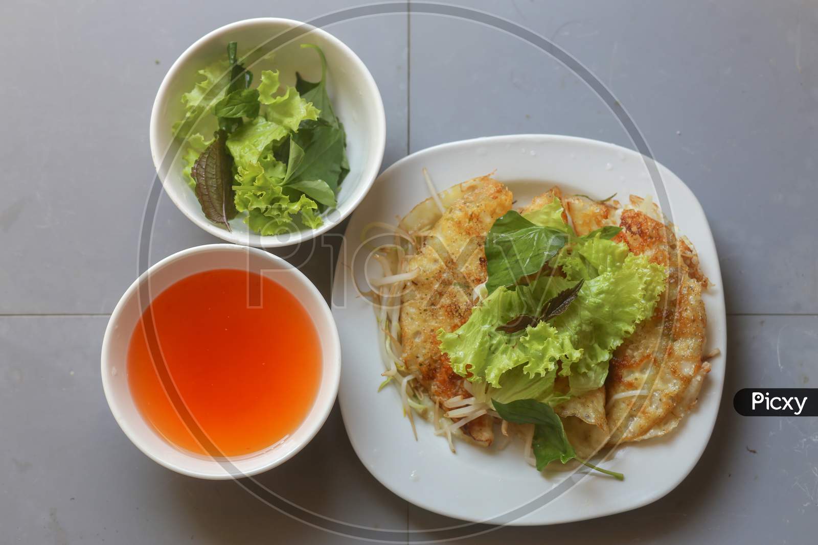 Close-Up Of Crispy Vietnamese Pancake With Fresh Vegetable And Fish Sauce