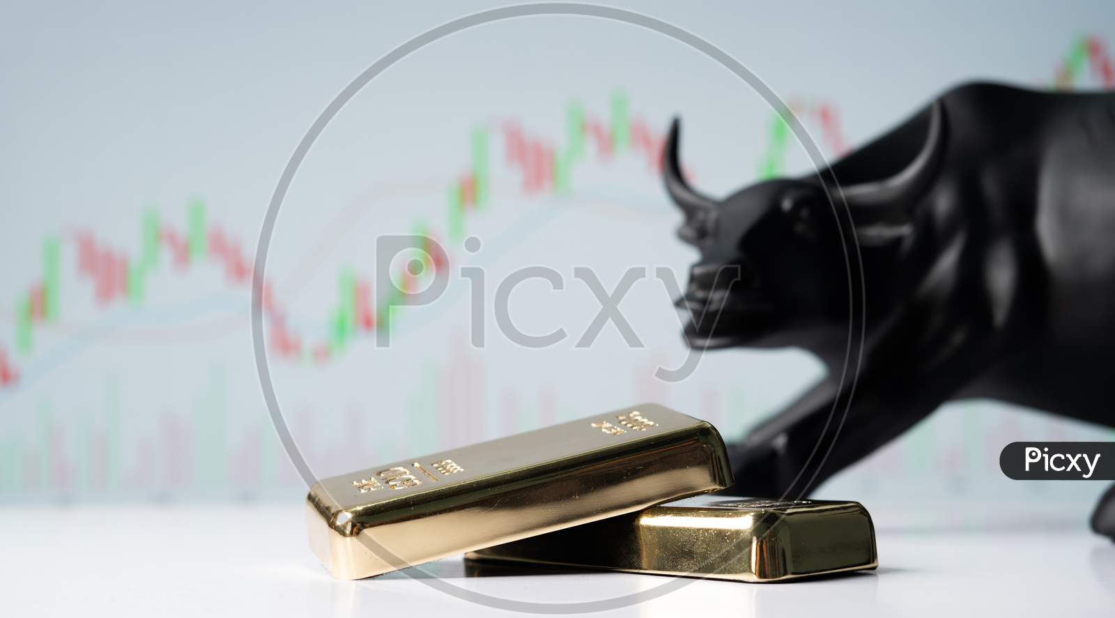 Focus On Gold Bars, Concept Of Bullish Or Boom In Gold Market Shares Or Stocks Showing By Bull Behind The Gold Bars With Charts In Background.