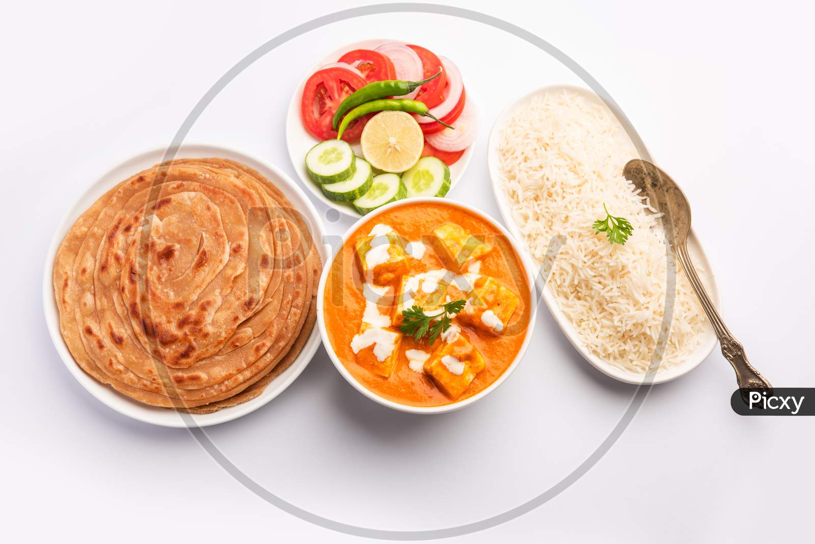 Paneer Butter Masala Or Cheese Cottage Curry Served With Rice And Laccha Paratha