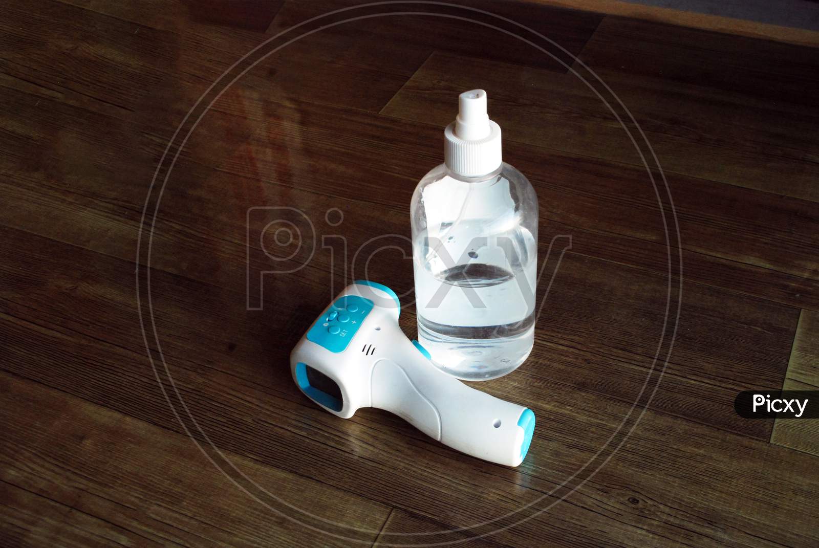 Closeup Of Hand Sanitizer Bottle And Thermometer Isolated On Wooden Floor Covid-19 Safety Objects