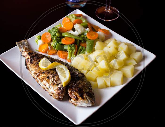 Grilled fish with potatoes and frozen vegetables