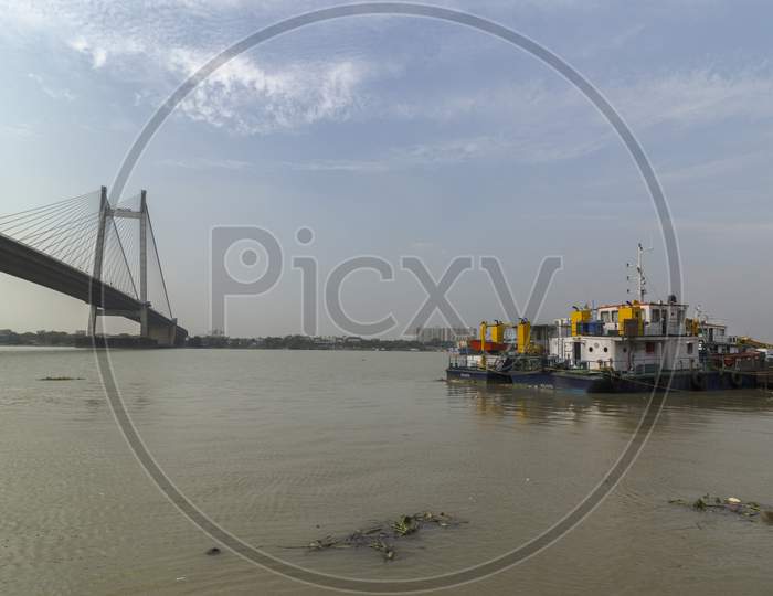 Anchored Floating Boats On River Hoogly With Vidyasagar Setu Or 2Nd Hoogly Bridge In Background.