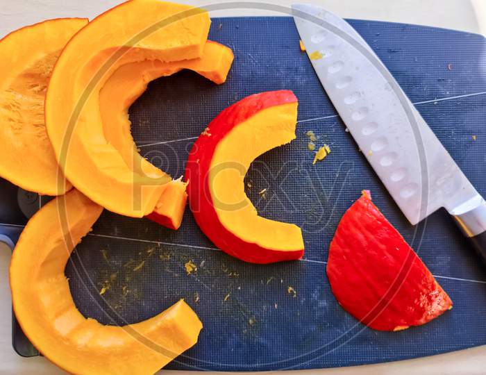 Slices Of Pumpkin With A Knife And A Cutting Board - Top View.