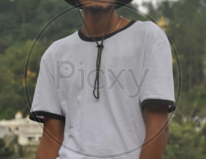 A north Indian young guy posing outdoor with wearing boonie hat and white tshirt and looking at camera