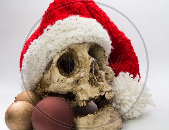 Human Skull With Christmas Ornaments And Elf Hat