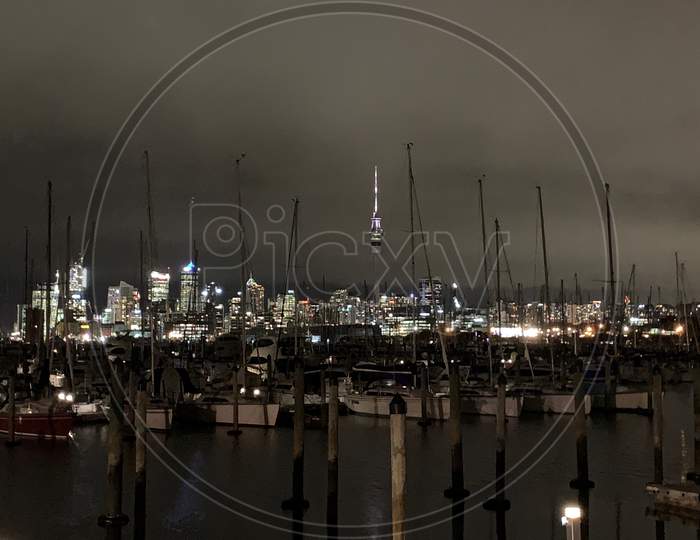 Auckland skyline from sea through boats in night
