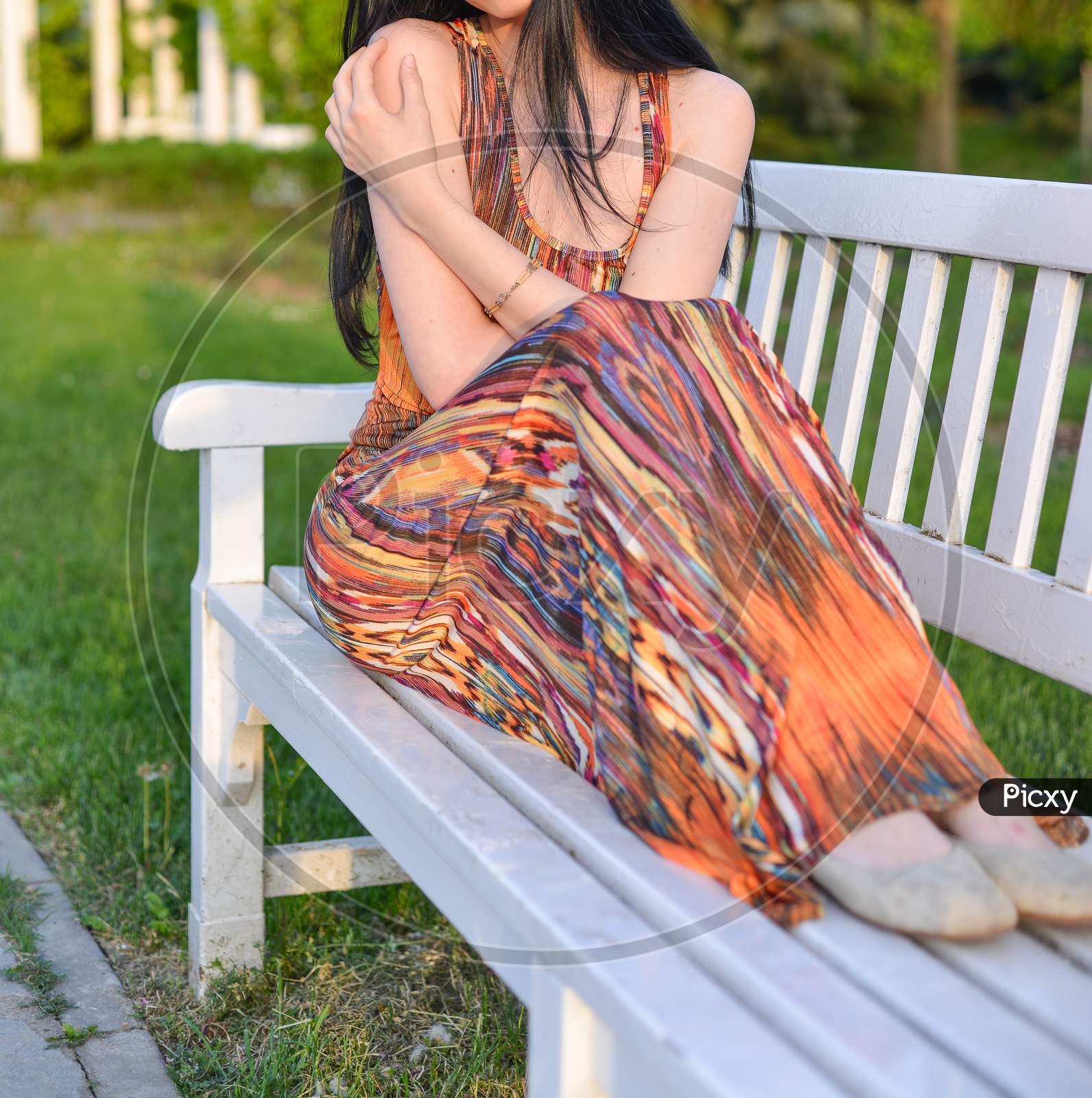 Timisoara, Romania - April 24, 2018: Beautiful Brunette Model With Long Hair Is Having A Photo Shooting In The Park. The Woman Is Wearing An Orange Long Summer Dress