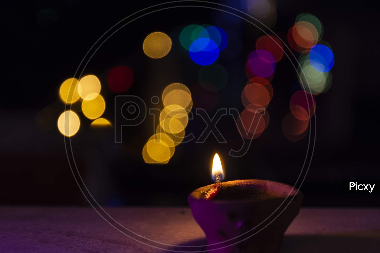 Diya candle light during diwali with colorful blurred background