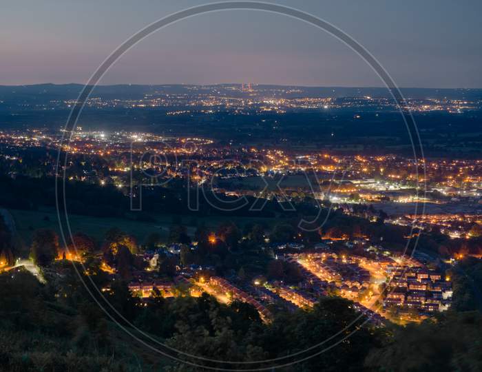 Dusk Or Night Time Landscape Over Small British Town Malvern, Showing Street Lamps, And Denser Populations In The Distance.