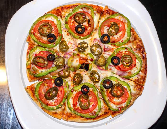 Fresh And Tasty Pizza With Vegetables, Tomato, Onion And Olives Isolated On White Plate. Top View