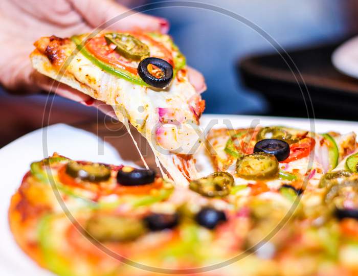 Slice Of Hot Pizza Large Cheese With Vegetables, Tomato, Onion And Olives. Close View