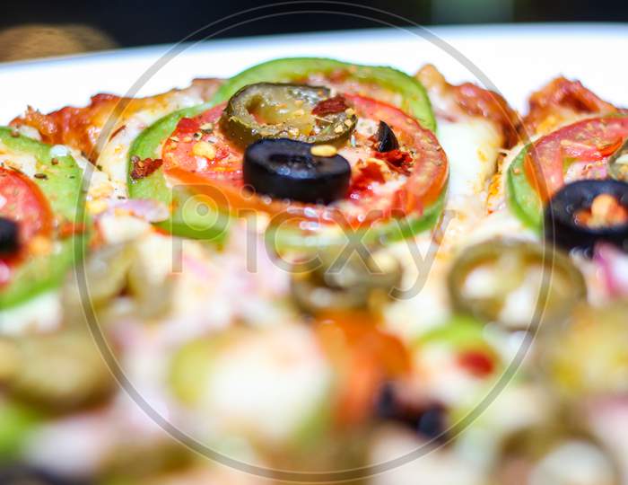 Fresh And Tasty Pizza With Vegetables, Tomato, Onion And Olives Isolated On White Plate. Close View.