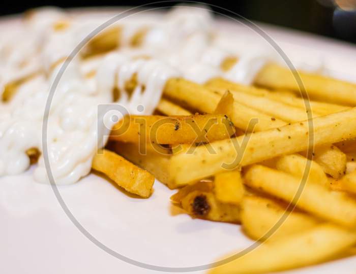 Close Up Of French Fries With Mayonnaise In A Plate.