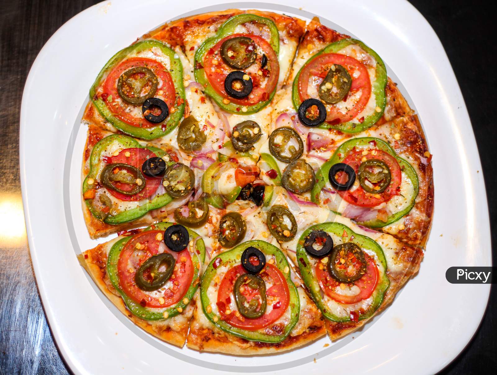 Fresh And Tasty Pizza With Vegetables, Tomato, Onion And Olives Isolated On White Plate. Top View