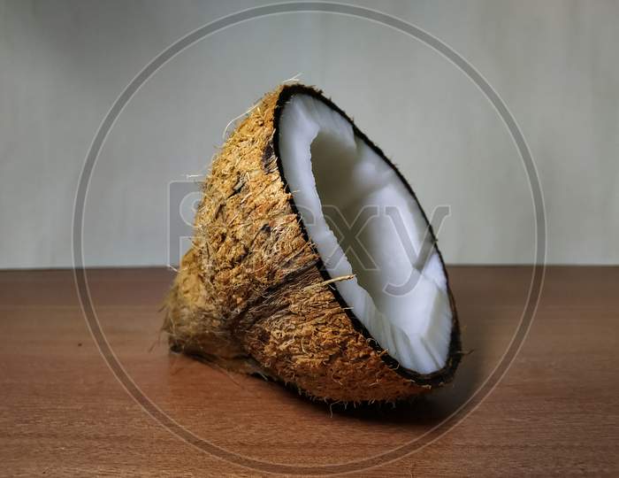 Half part of coconut on wooden surface