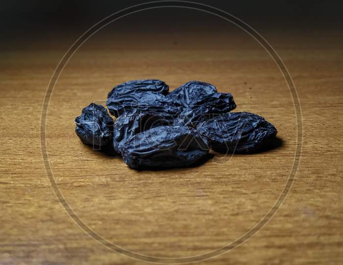 Dry prunes on wooden surface
