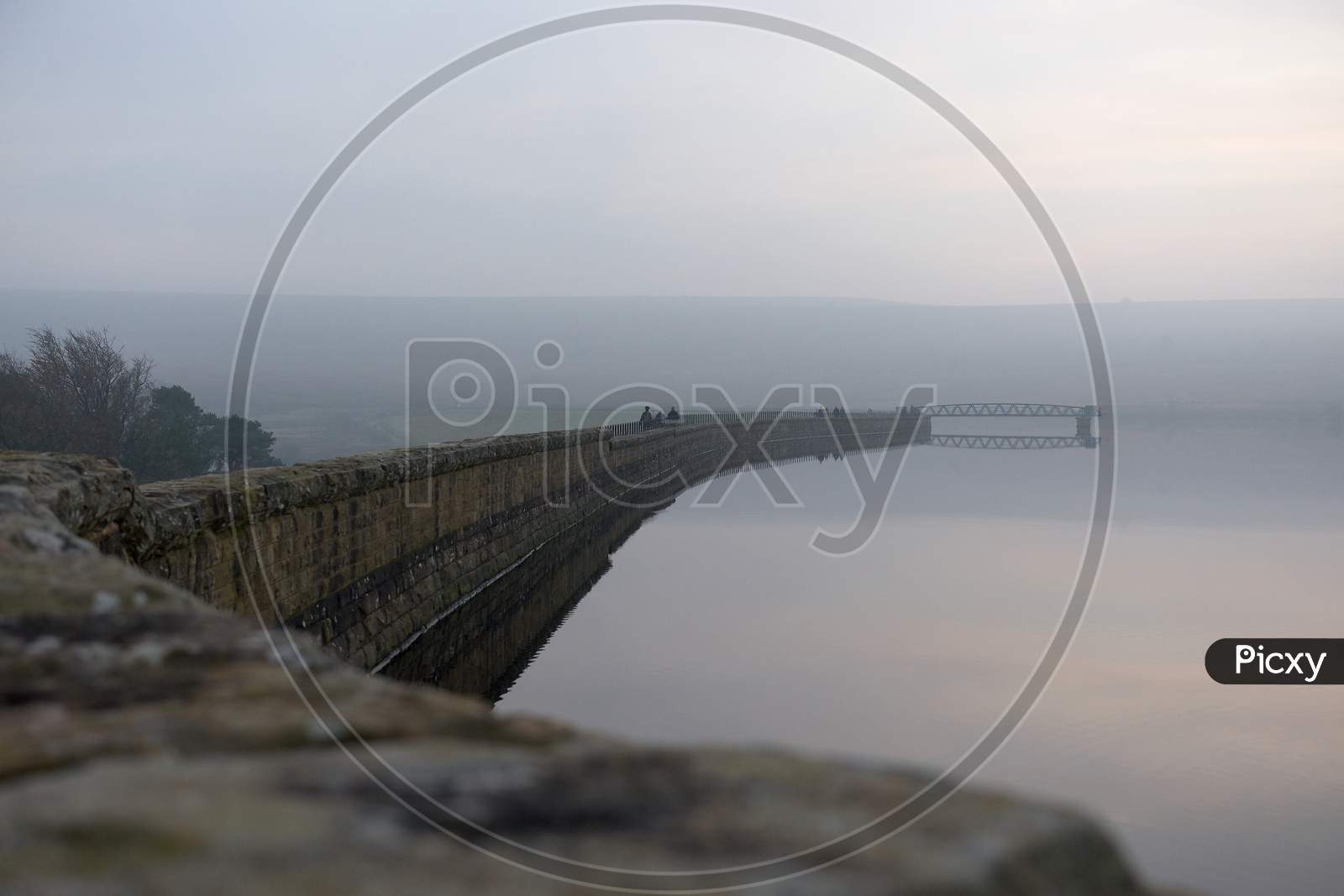 People Enjoy A Winters Walk Along Redmires Dam Wall. Misty Conditions