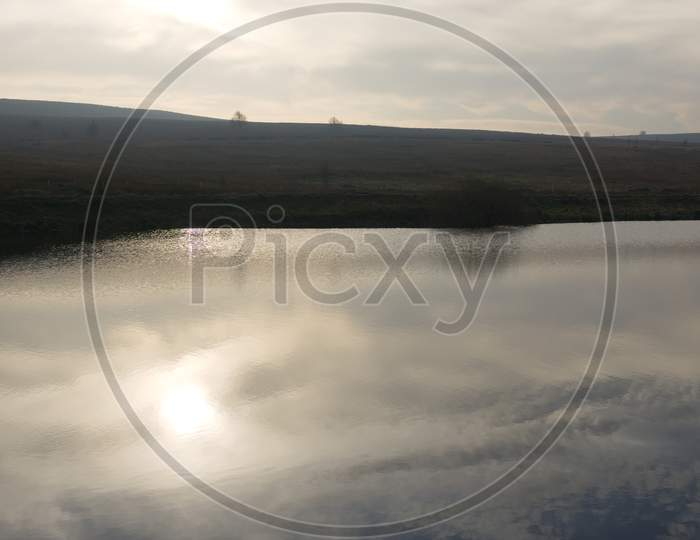 Vertical Image Of Blue Cloudy Sky Reflected In Redmires Top Reservoir