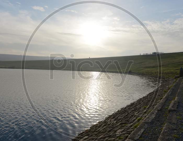 Groups Of People Walk Along The Top Dam At Redmires Reservoirs. Sunny