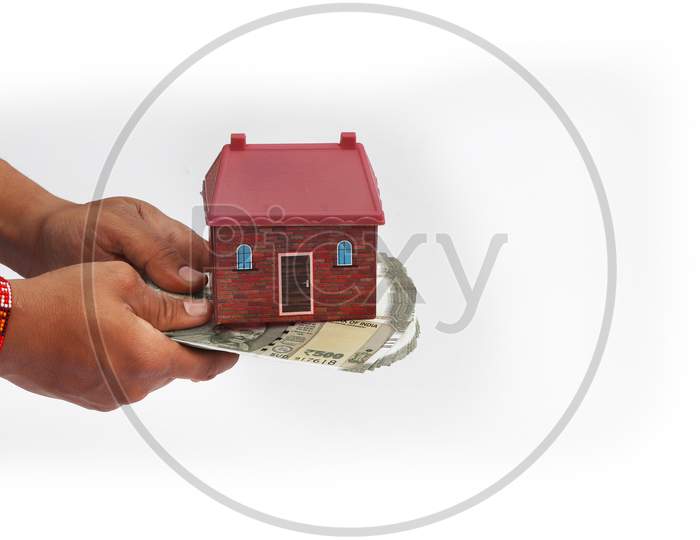 Close Up Of Hands Giving House Model With Indian Currency Notes. Concept Of Home, Real Estate And Deal Isolated On White Background