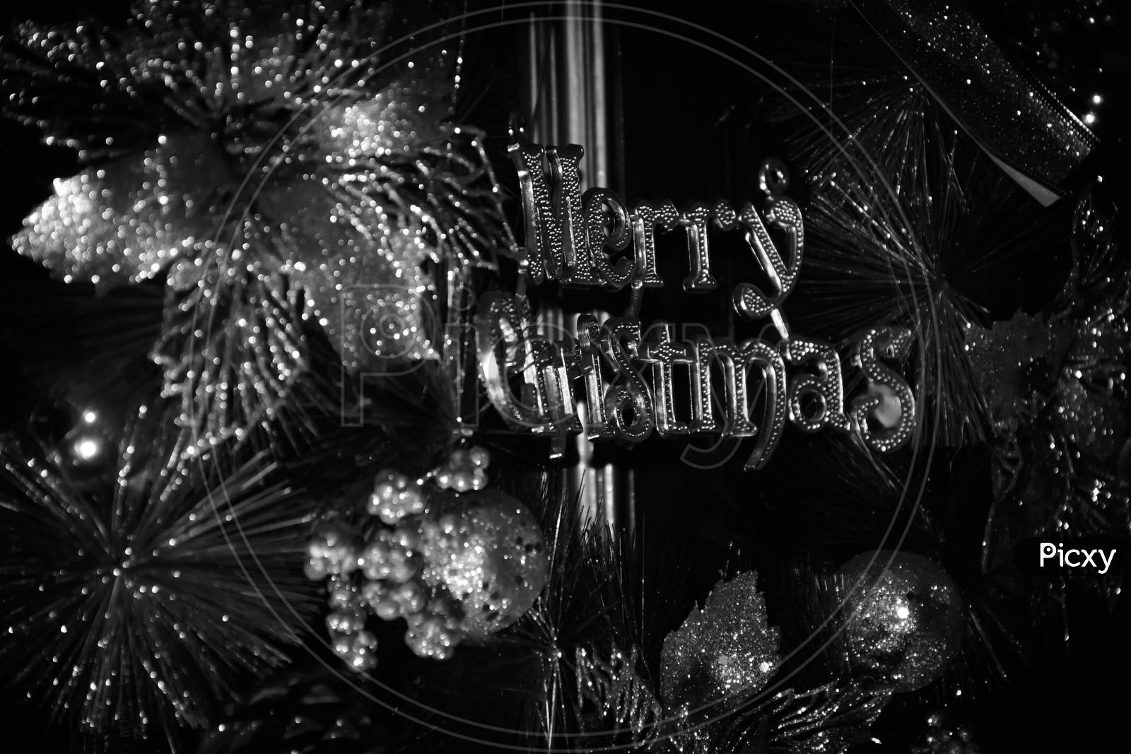 White And Black Photo Of A Decorative Christmas Wreath With Merry Christmas Text On Brown Wooden Door