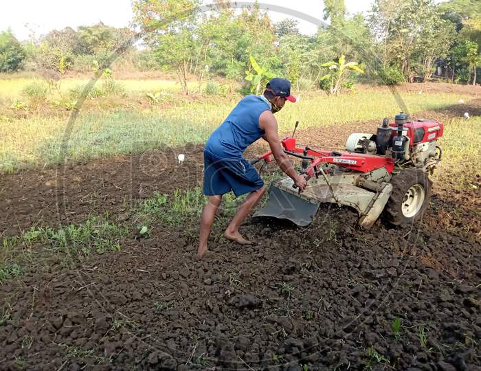 PALGHAR, MAHARASHTRA, INDIA - DESEMBER 26 2021: The field is plowed with sand by tractor, tractor machine name (Tillage with VST Shakti 130 DI)