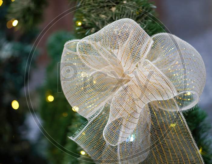 Close Up Ribbon Decoration At Christmas Tree.