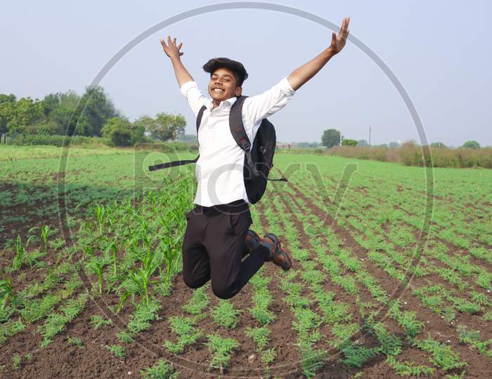Happy Indian Child Jumping Agriculture Field.