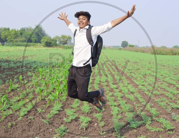 Happy Indian Child Jumping Agriculture Field.
