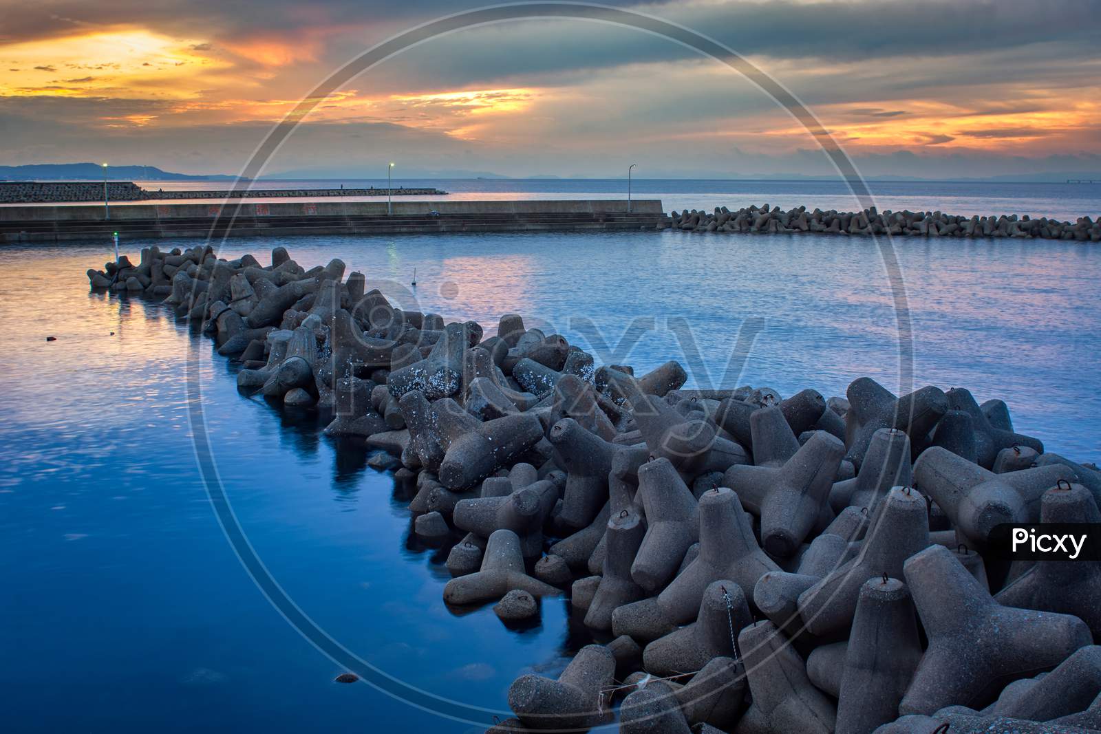 Beautiful View Of A Seascape With Tetrapod Breakwaters Under The Sunset Sky