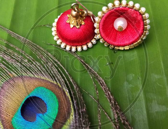 Red thread and  pearl jhumka with peacock feather