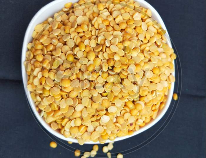 One bowl of yellow split pigeon peas pulse with black background