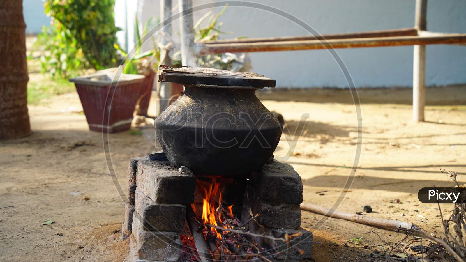 Illuminating Fire In Natural Clay Stove In Rural Village Of Rajasthan India. Pan Or Aluminum Pot On The Stove.