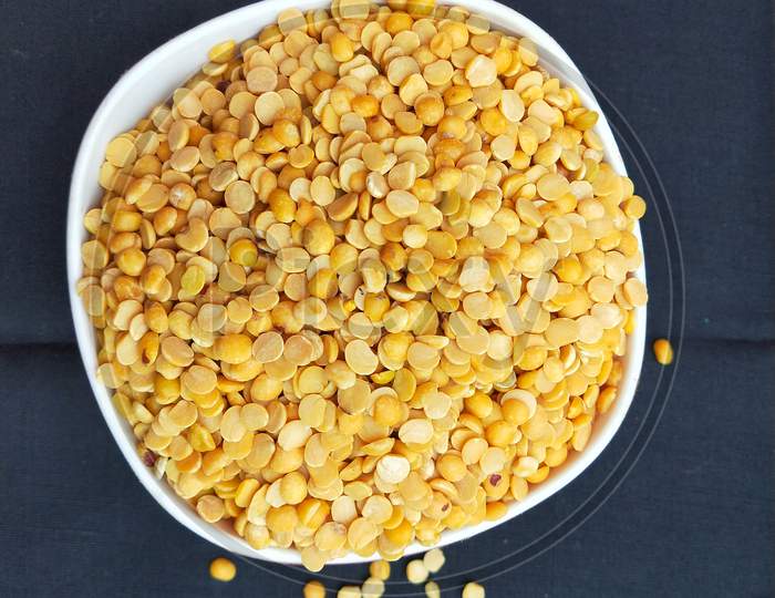 One bowl of yellow split pigeon peas pulse with black background