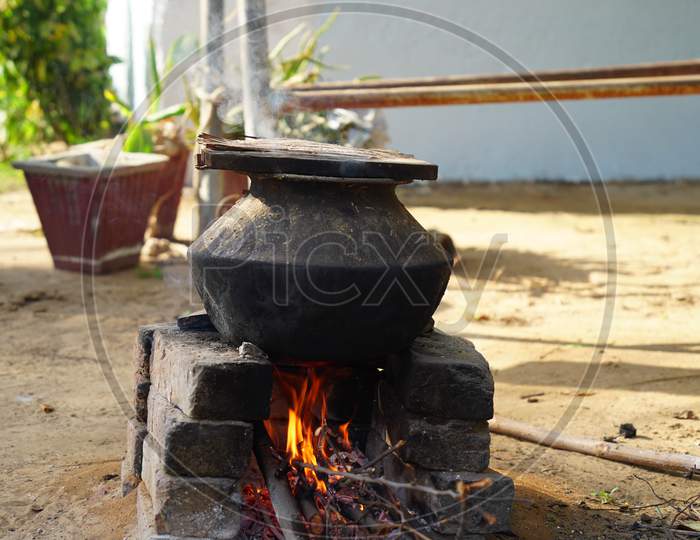 Illuminating Fire In Natural Clay Stove In Rural Village Of Rajasthan India. Pan Or Aluminum Pot On The Stove.