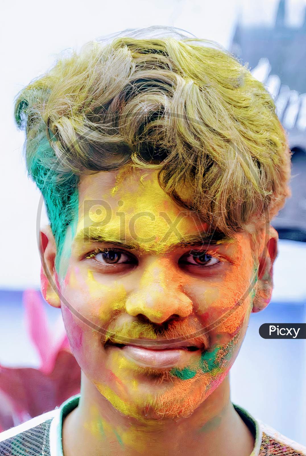 A middle aged indian boy with colours on face in Holi festival