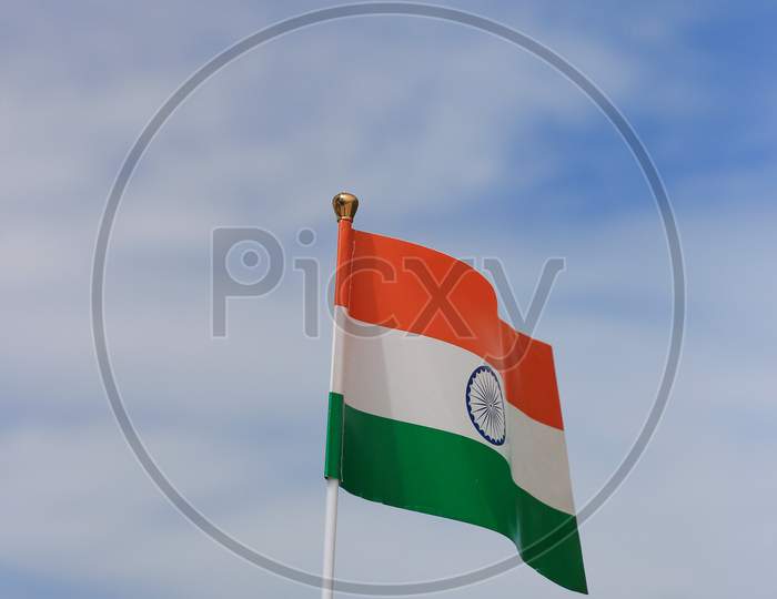Vertical shot of the Indian flag in the blue sky