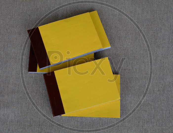 Yellow Color Bill Books Or Receipt Books On A Cream Color Furnishing Cloth
