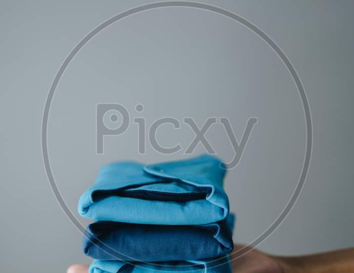 Eco friendly cloth sanitary pads held in hand against a grey background